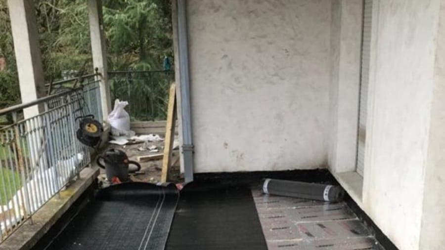 Toit-terrasse : panneaux isolants posés et membrane bitume en cours de déroulage