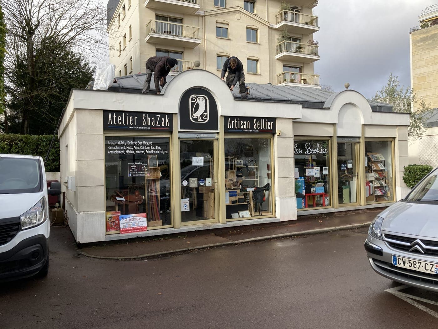 Deux couvreurs au travail sur la toiture d'un local commercial