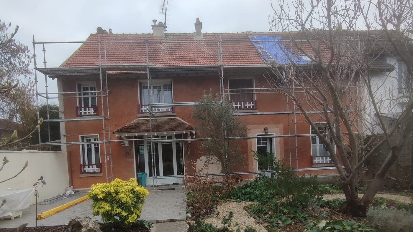 Maison de brique échafaudée sur toute sa hauteur pour une réfection de toiture