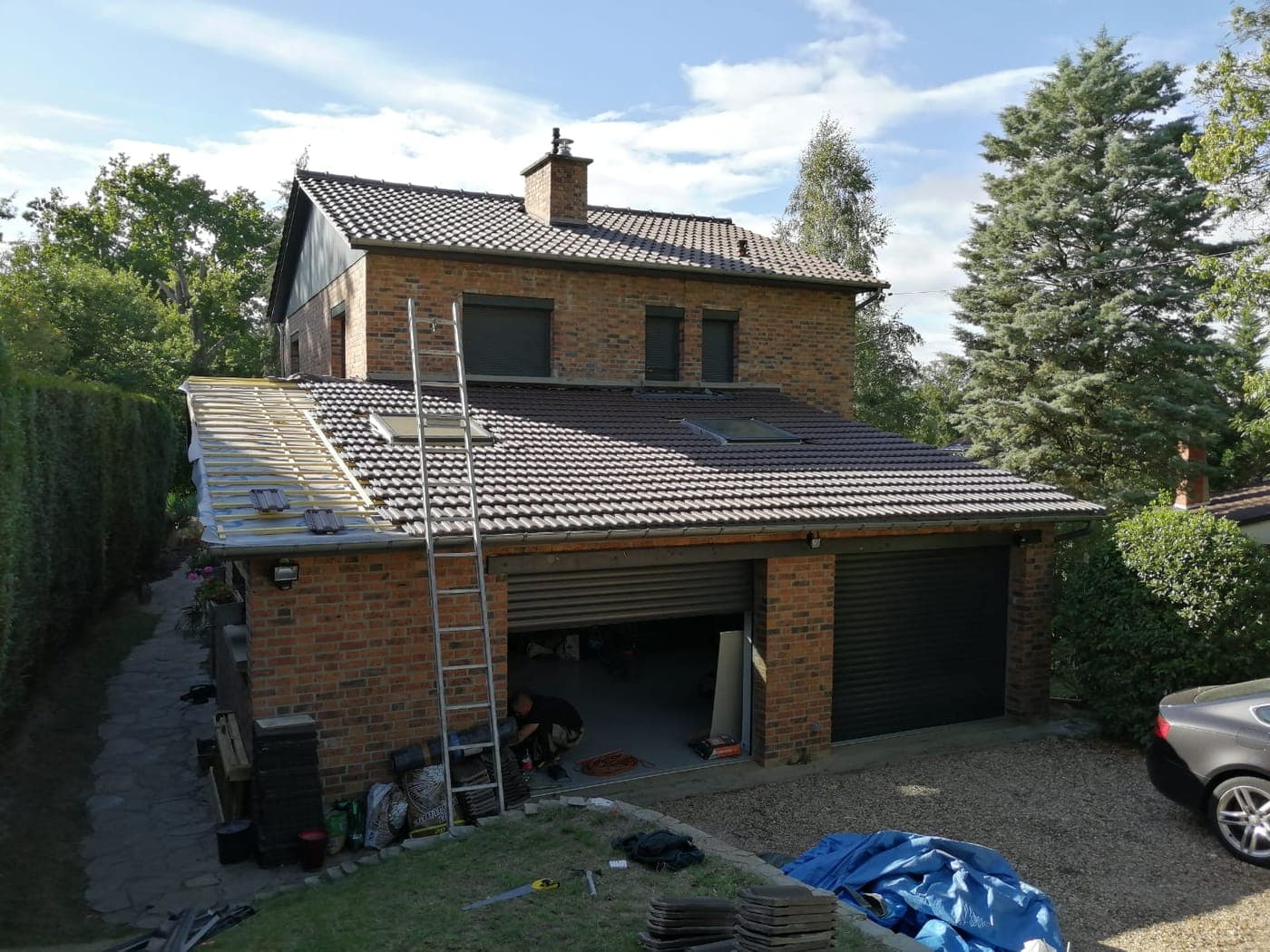 Chantier de couverture sur une maison de brique et son garage attenant